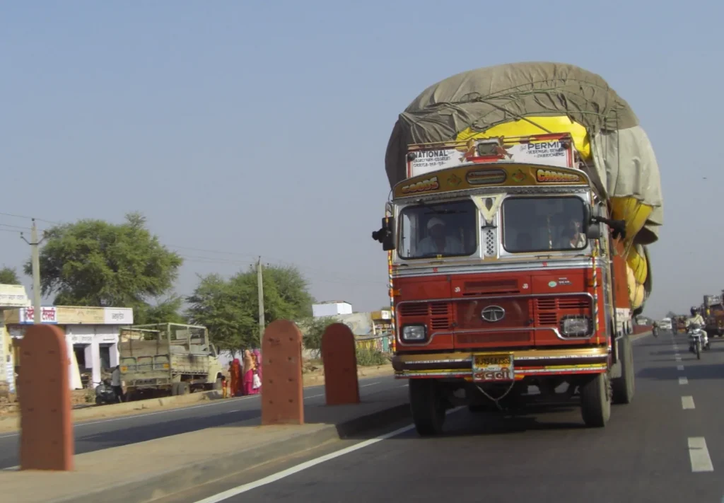 Fully loaded Indian goods truck covered with tarpaulin on the road