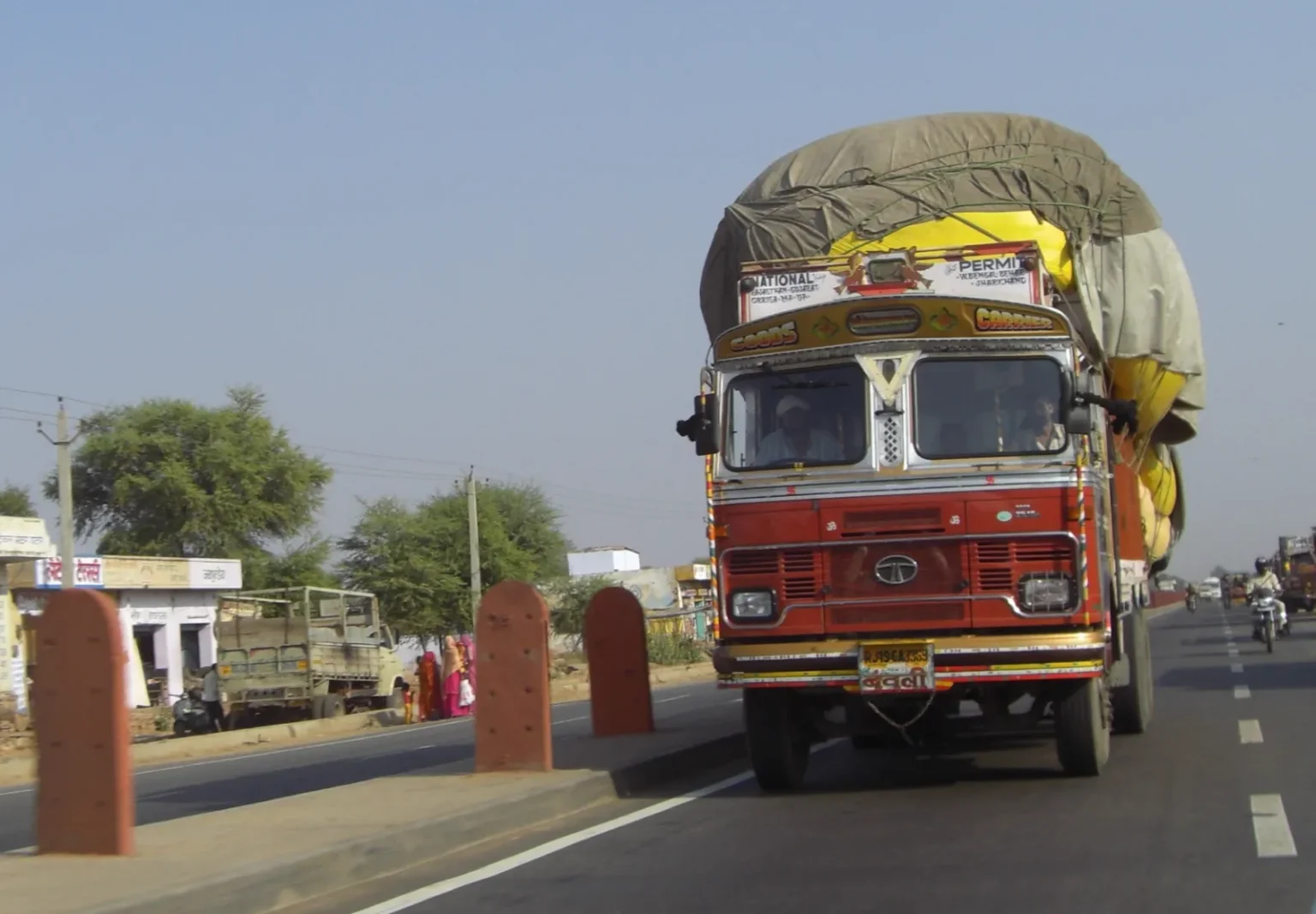 Fully loaded Indian goods truck covered with tarpaulin on the road